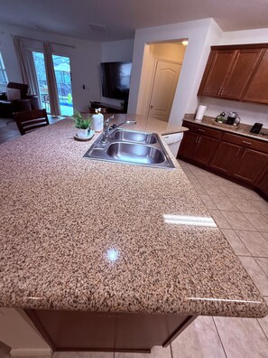 A kitchen with granite countertops, stainless steel appliances, and wooden cabinets.