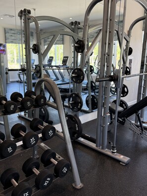 Ein Fitnessstudio mit Gewichten, Laufbändern und Kurzhanteln.