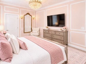 Une chambre à coucher avec un lit, une commode, un miroir et un téléviseur.
