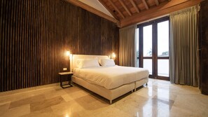 A spacious bedroom with a large bed, wooden panel walls, and a view through a glass door. - Modern 7 Bedroom Mansion in Old City (Cartagena de Indias)