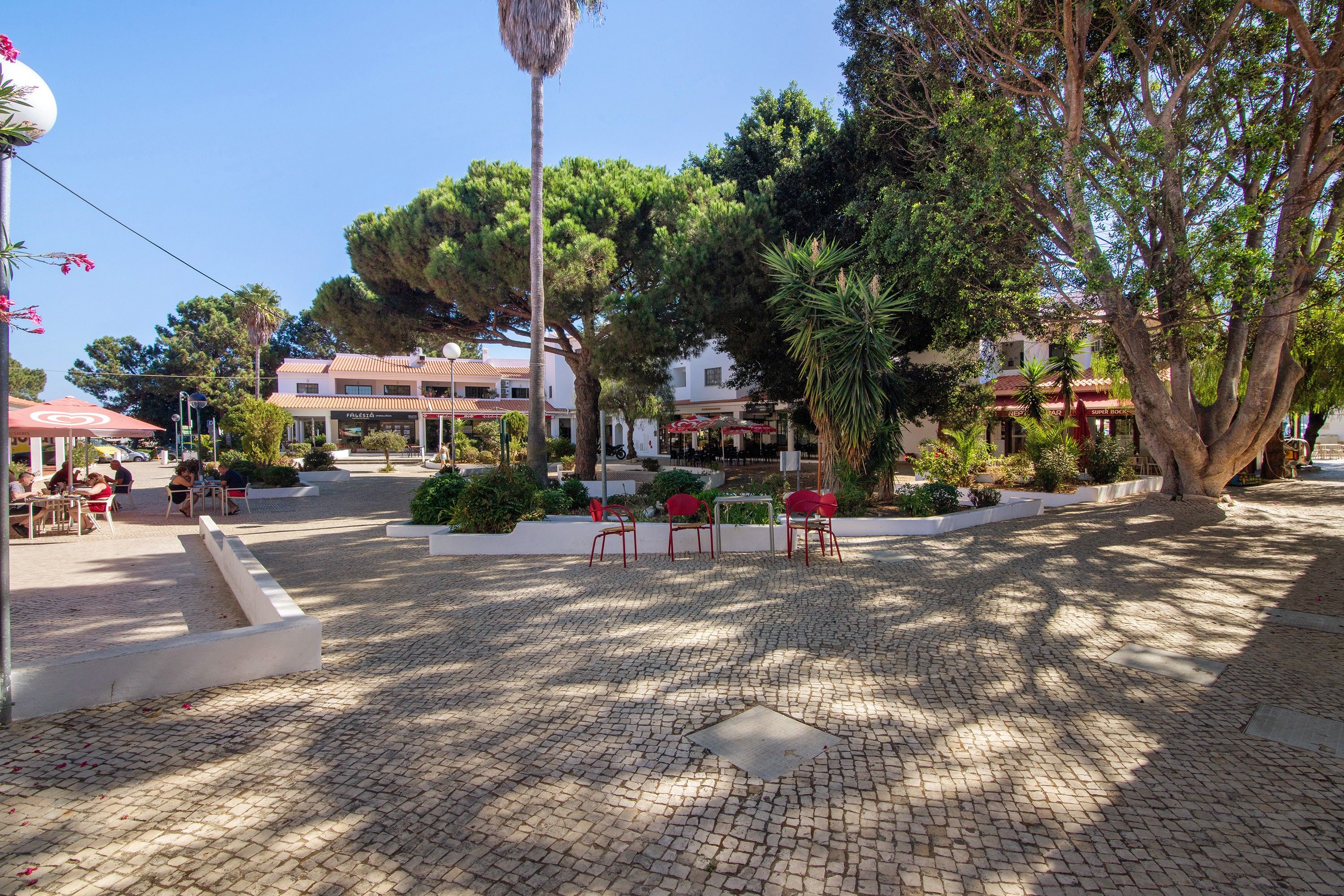 A paved courtyard with outdoor seating and trees.