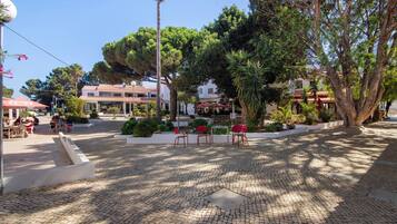 A paved courtyard with outdoor seating and trees.