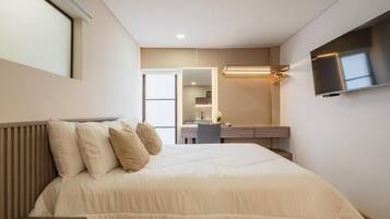 Un dormitorio moderno con cama, mesita de noche y televisión en la pared.