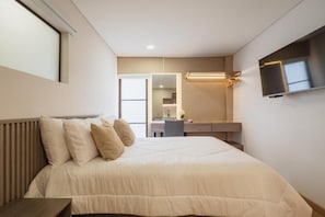 A modern bedroom with a bed, bedside table, and a TV mounted on the wall. - Casa Juné (Pereira)