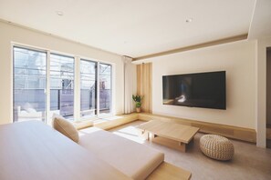A modern bedroom with a large bed, a TV mounted on the wall, and a sliding glass door leading to a balcony. - New Listing (新宿区中落合１丁目２１－３　中落合ホテル)
