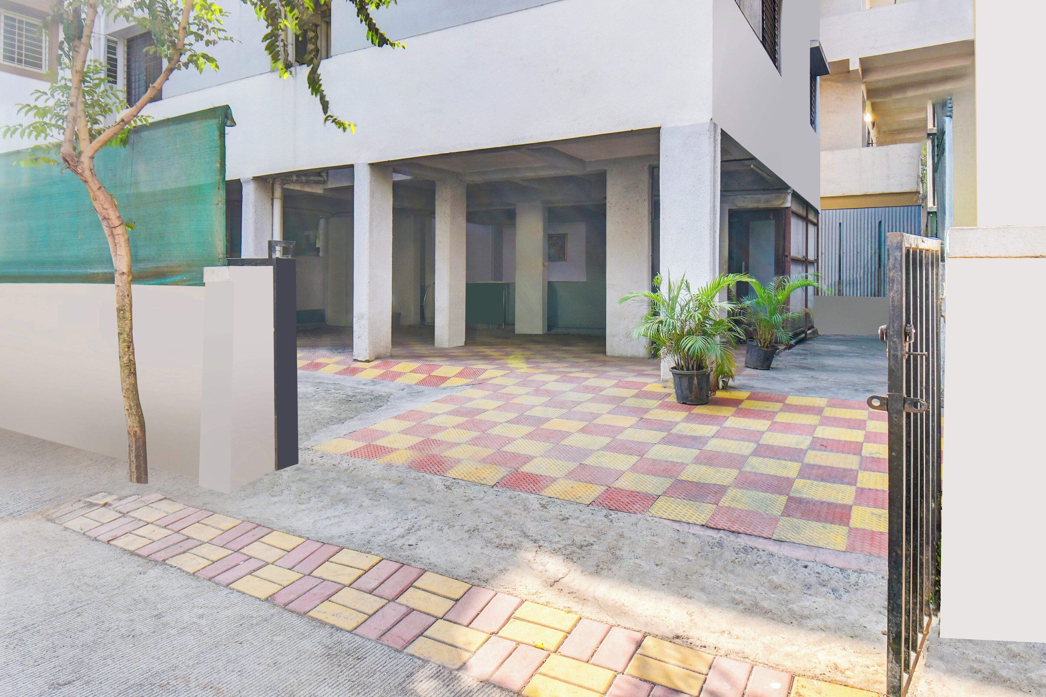 Un patio con piso a cuadros, una puerta y una planta en maceta.
