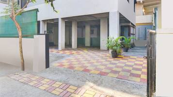 Un patio con piso a cuadros, una puerta y una planta en maceta.