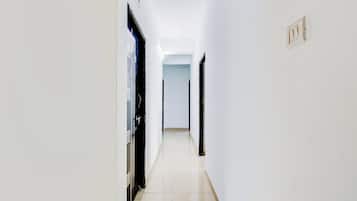 Un pasillo estrecho con puertas a ambos lados, que conduce a habitaciones.