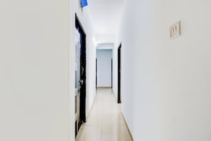 Un pasillo estrecho con puertas a ambos lados, que conduce a habitaciones.