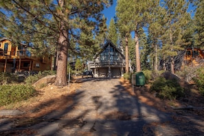 A cabin with a garage, surrounded by pine trees. - Ludwig's Lodge: 5 Bedroom, 3 bathroom Dollar Point home. (Tahoe City)