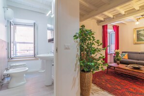 A modern bathroom with a large window, a sink, and a bidet. - Pettinara Suites (Viterbo)