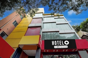 Un hotel de varios pisos con una fachada moderna, que presenta un letrero destacado que dice 'HOTEL' y una etiqueta 'YOYO-Serviced'.