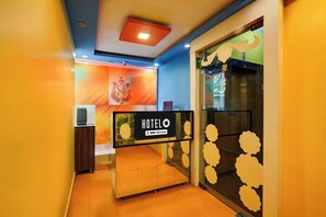 A hotel reception area with a sign indicating it is serviced by OYO.
