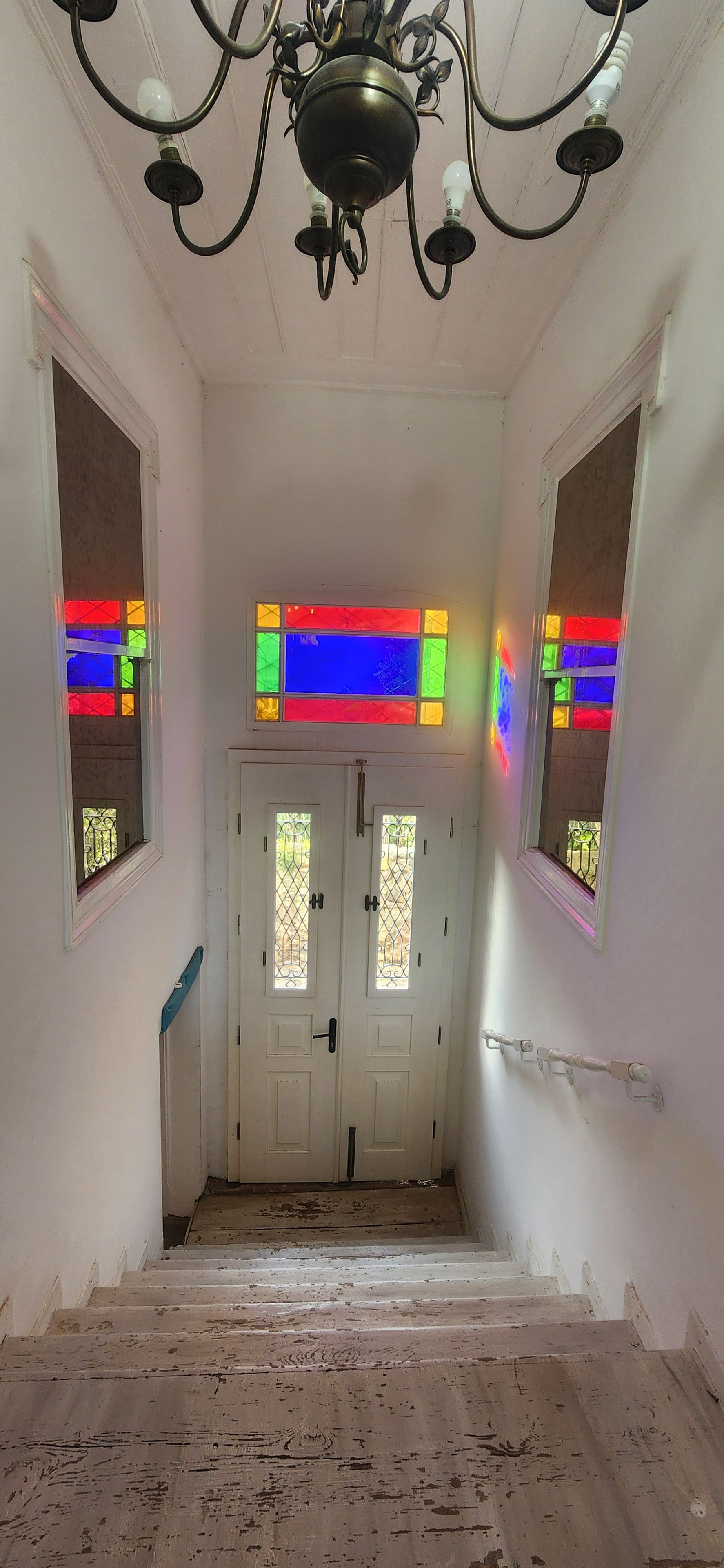 A staircase leading to a door with stained glass windows.