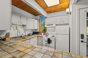 A modern kitchen with white cabinetry, a tiled backsplash, and a wooden ceiling. - Ski Ranch 204 - 2 bedroom + loft, walk to the resort! (Steamboat Springs)