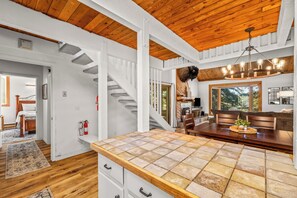A spacious kitchen with a large island, wooden ceiling, and a cozy seating area with a fireplace. - Ski Ranch 204 - 2 bedroom + loft, walk to the resort! (Steamboat Springs)