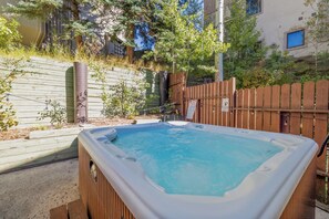 Ein Whirlpool in einem Garten mit Holzzaun und Holzterrasse.