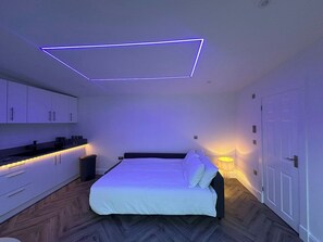 A bedroom with a bed, bedside table, and a wall-mounted light fixture. - Amazing guest house for a romantic get away (Edinburgh)