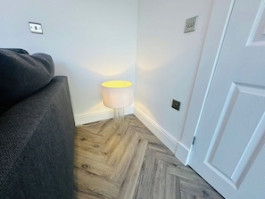 A room with a grey sofa, a lamp, and a door. - Amazing guest house for a romantic get away (Edinburgh)