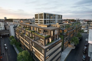 Ein mehrstöckiges Gebäude mit Dachgarten und modernem Design.