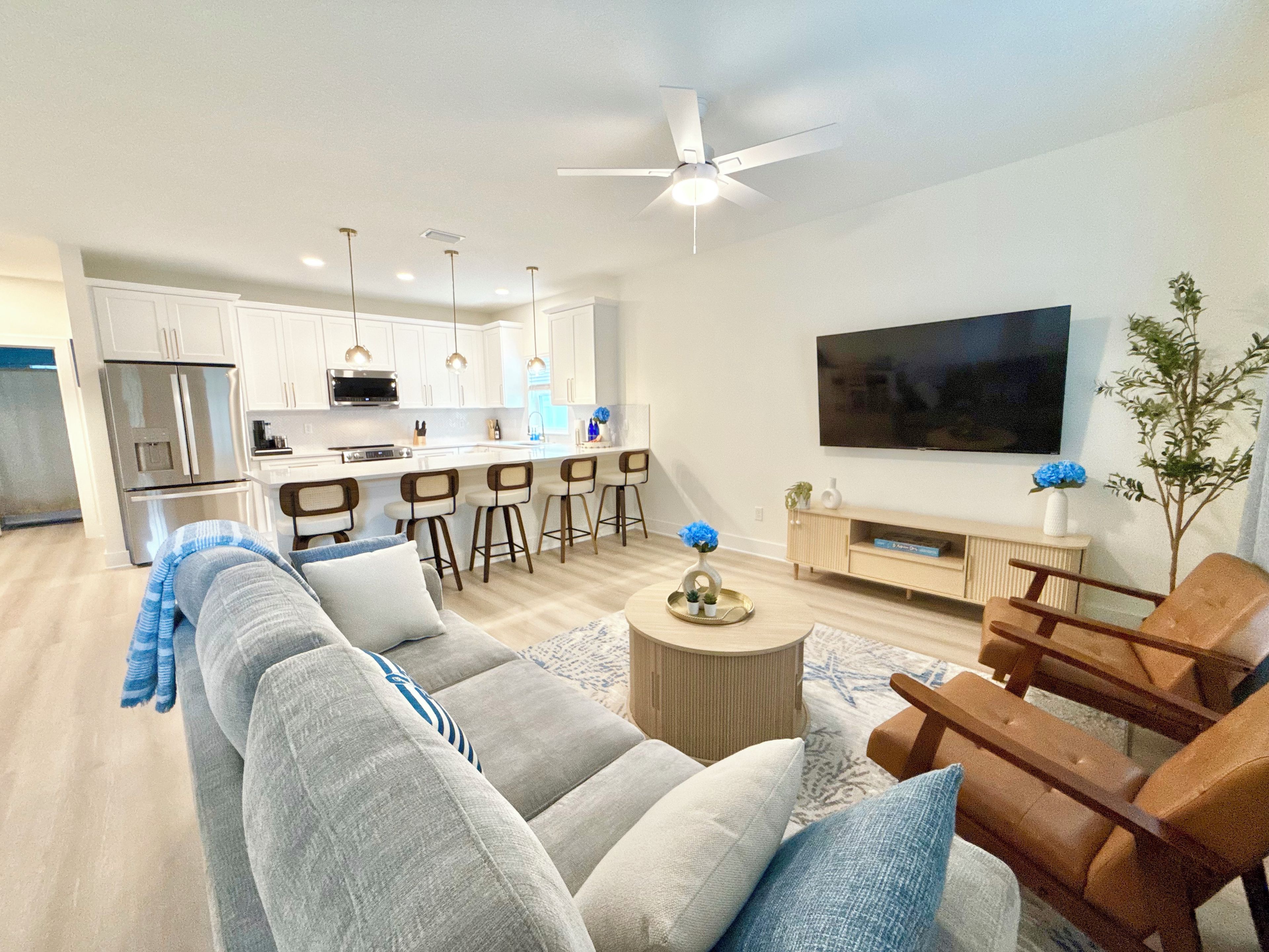 A modern living room with a sofa, coffee table, and a TV mounted on the wall.