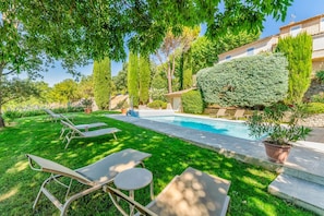 A poolside area with lounge chairs, a swimming pool, and a well-maintained garden. - Villa Les Vignes - Four Bedroom Villa, Sleeps 10 (Joucas)