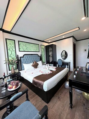 A hotel room with a bed, bedside table, chair, and a desk with a mirror. - vincentluxury (yên nghĩa)