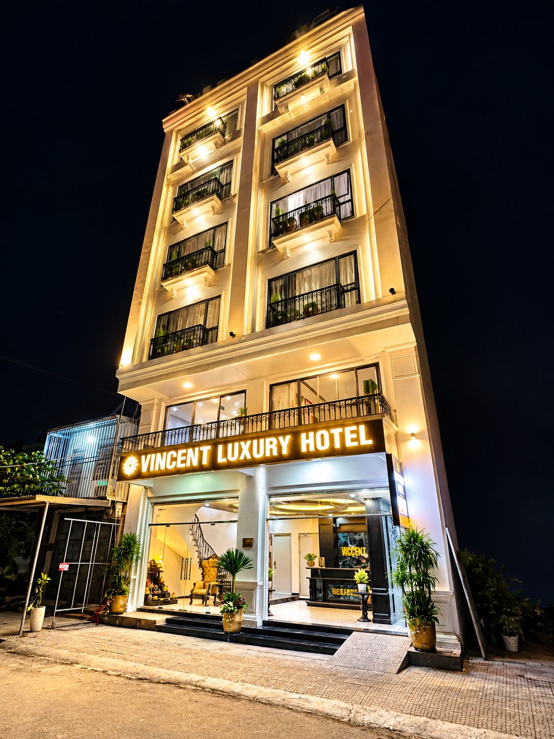 A multi-story building with a sign reading 'VINCENT LUXURY HOTEL'.