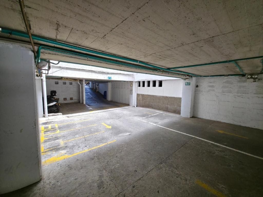 Een ondergrondse parkeergarage met betonnen wanden, gele parkeerlijnen en een zichtbare motor.