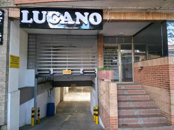 A storefront with a sign reading 'LUCANO' and a visible entrance to a building. - Hotel Lugano (Medellín)