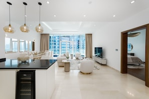 A modern living room with a dining area, large windows, and a view of the cityscape. - Refined 1BR Haven Palm Jumeirah (Dubai)