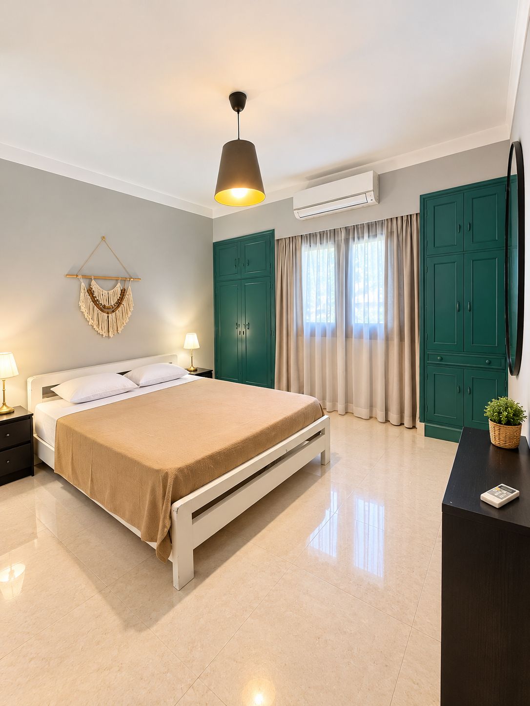 A bedroom with a bed, bedside tables, an air conditioning unit, a wall-mounted TV, and a green wardrobe.