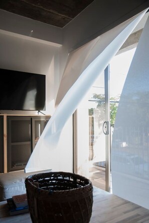 A room with a large window, a television on a stand, and a woven basket on a table. - 201-Tropical Refuge Near Wynwood+Rubell Museum (Miami)