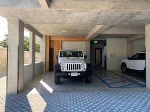 Een parkeergarage met een witte SUV en een witte auto erin.