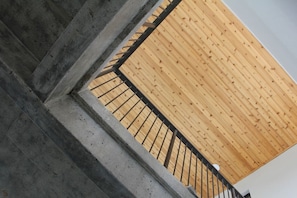 Un bâtiment moderne à la structure en béton et doté d’un toit en pente recouvert de bois.