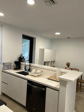 A modern kitchen with a dishwasher, sink, and a coffee machine. - 202-Tropical Refuge Near Wynwood+Rubell Museum (Miami)