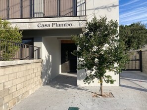 A building named 'Casa Flambo' with a gated entrance, a small tree in front, and a paved walkway. - 202-Tropical Refuge Near Wynwood+Rubell Museum (Miami)