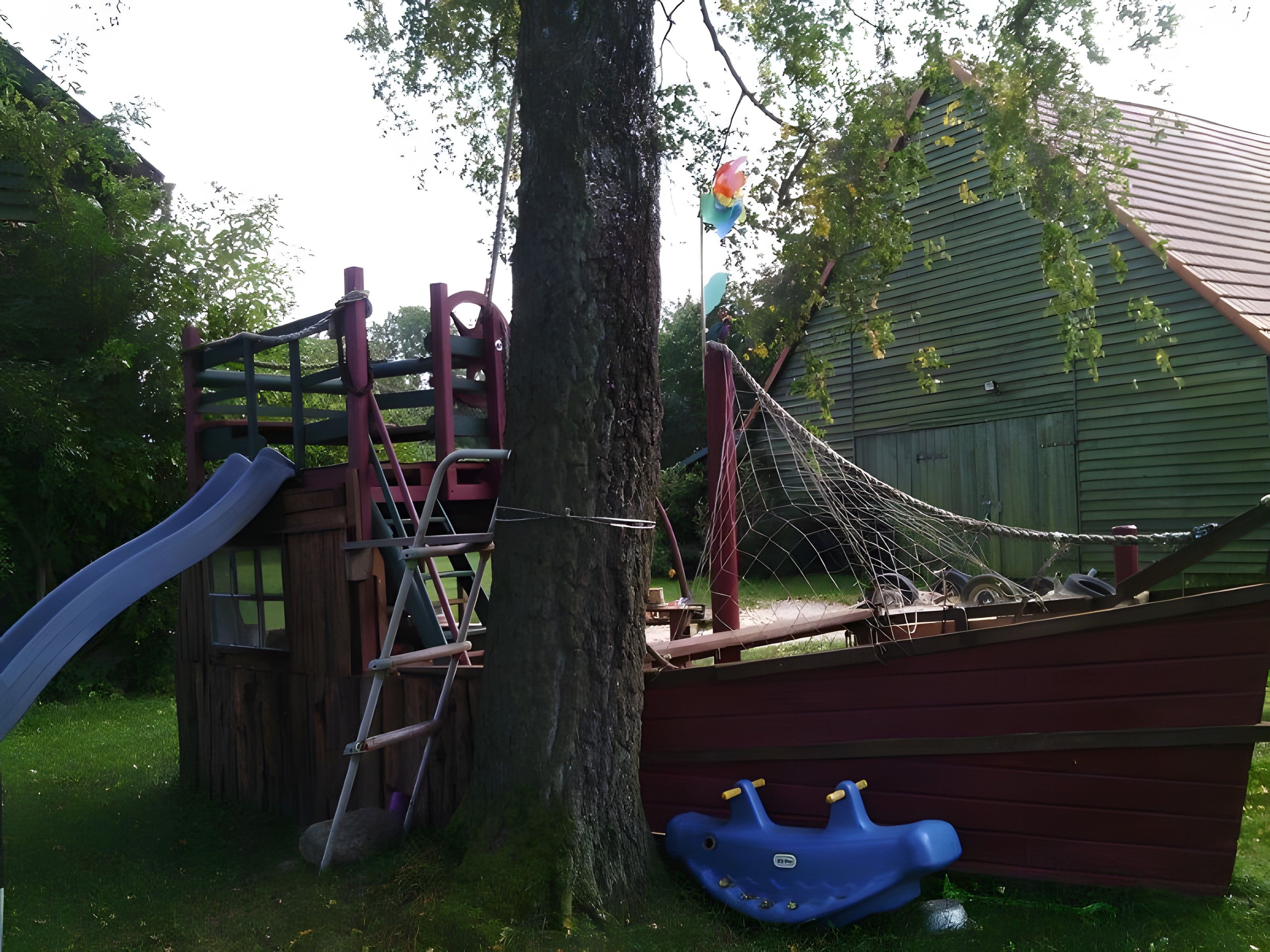 Ein Spielplatz mit Rutsche, Klettergerüst und Schaukeln.