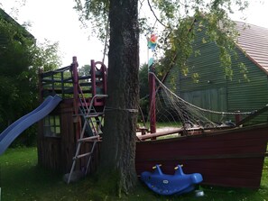 A playground with a slide, climbing structure, and swing set.