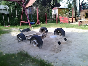 A playground with a swing set, tire play structures, and a sandbox. - Apartment 'FeWo Hannehof' with Shared Terrace, Shared Garden and Wi-Fi (Tessin)
