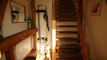 A staircase with wooden steps and a handrail, leading to an upper floor.