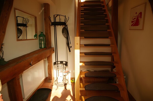 A staircase with wooden steps and a handrail, leading to an upper floor.