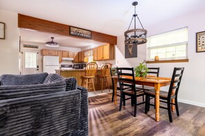 A modern kitchen with wooden cabinets, a dining table with chairs, and a chandelier. - Newly Remodeled 3-bedroom escape nestled in the woods of Jim Thorpe Pennsylvania (Jim Thorpe)