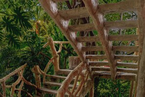 Un escalier en bois au design rustique, entouré d’une végétation luxuriante.