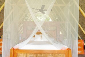 Un lit avec une tête de lit en bois et un baldaquin.