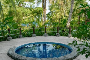 A circular pool surrounded by a concrete deck, with a rope barrier and stone pillars. - Casa Santa María – Secluded Beachfront Home (Matapalo)