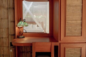 A wooden desk with a lamp and a window overlooking a wooden deck. - Casa Santa María – Secluded Beachfront Home (Matapalo)