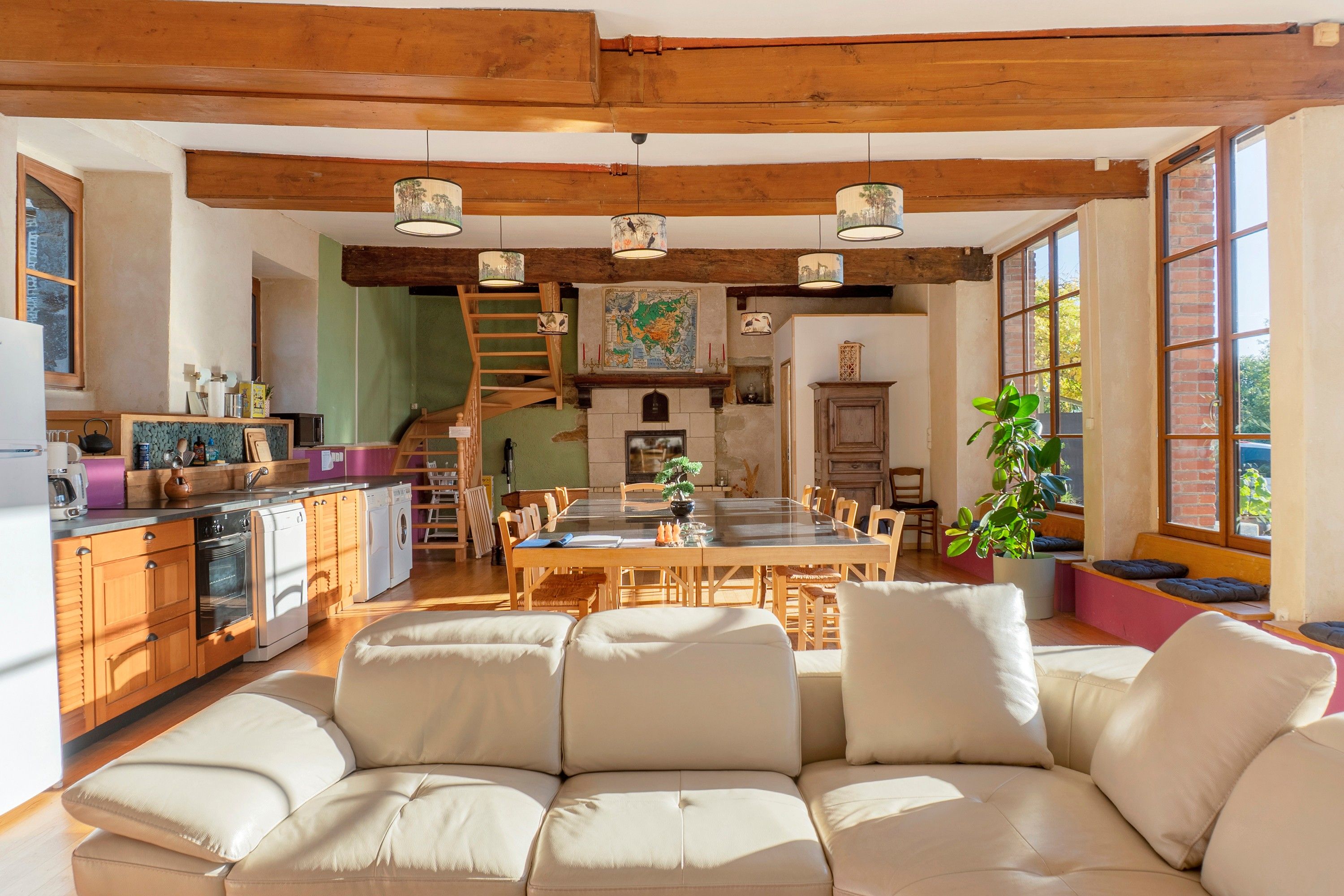A spacious living area with a sofa, dining table, and kitchen area.