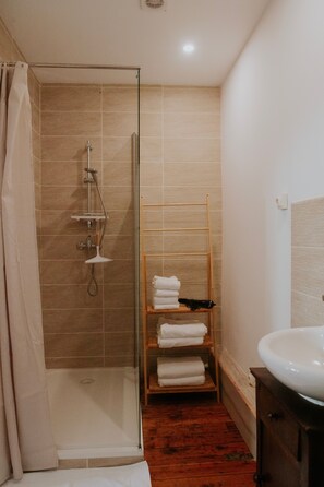 A bathroom with a glass-enclosed shower, a wooden towel rack, and a sink. - Cottage 'Gite Charlemagne' with private terrace, private garden and Wi-Fi (Mauron)