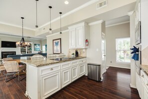 A spacious kitchen with white cabinetry, a granite countertop, and a stainless steel trash can. - Spacious Bayfront Retreat - Pet Friendly with Private Fishing Pier (Galveston)